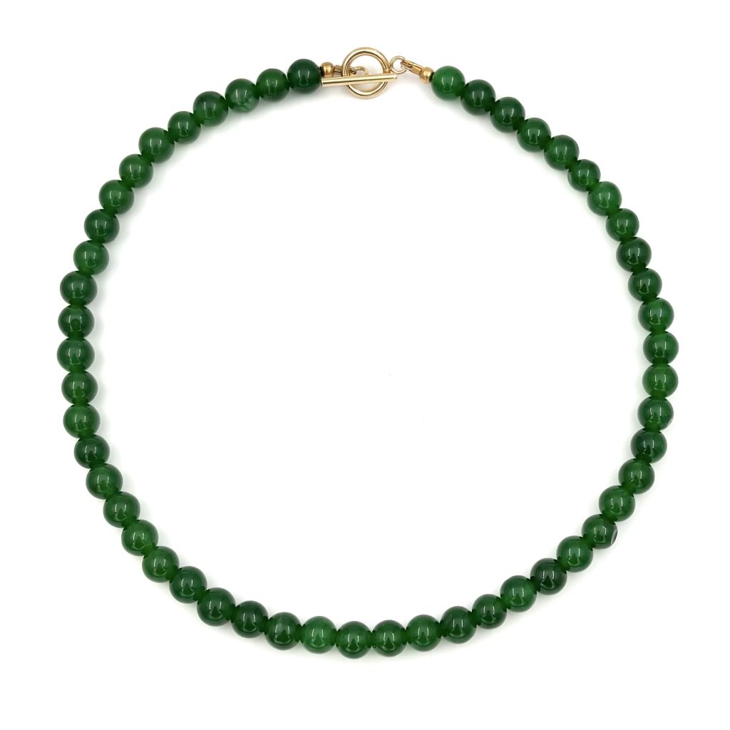 halsband med gröna stenpärlor och ett guldfärgat stavlås
