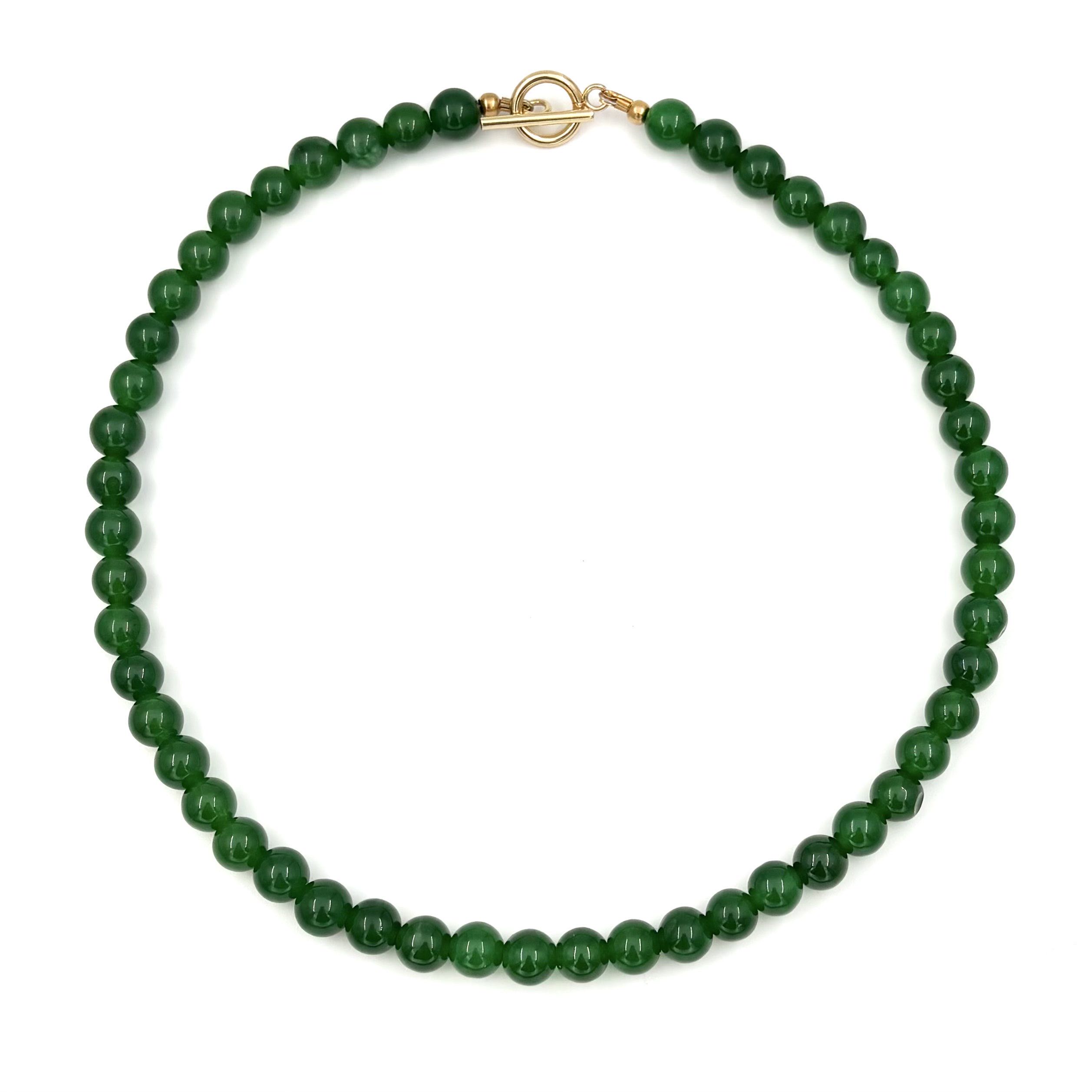 halsband med gröna stenpärlor och ett guldfärgat stavlås