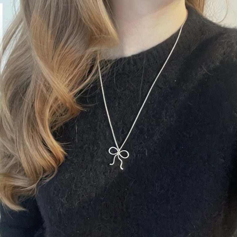 modellbild på silvrigt halsband med en rosett på