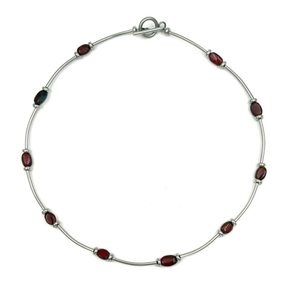 produktbild på silvrigt halsband med granat-stenar