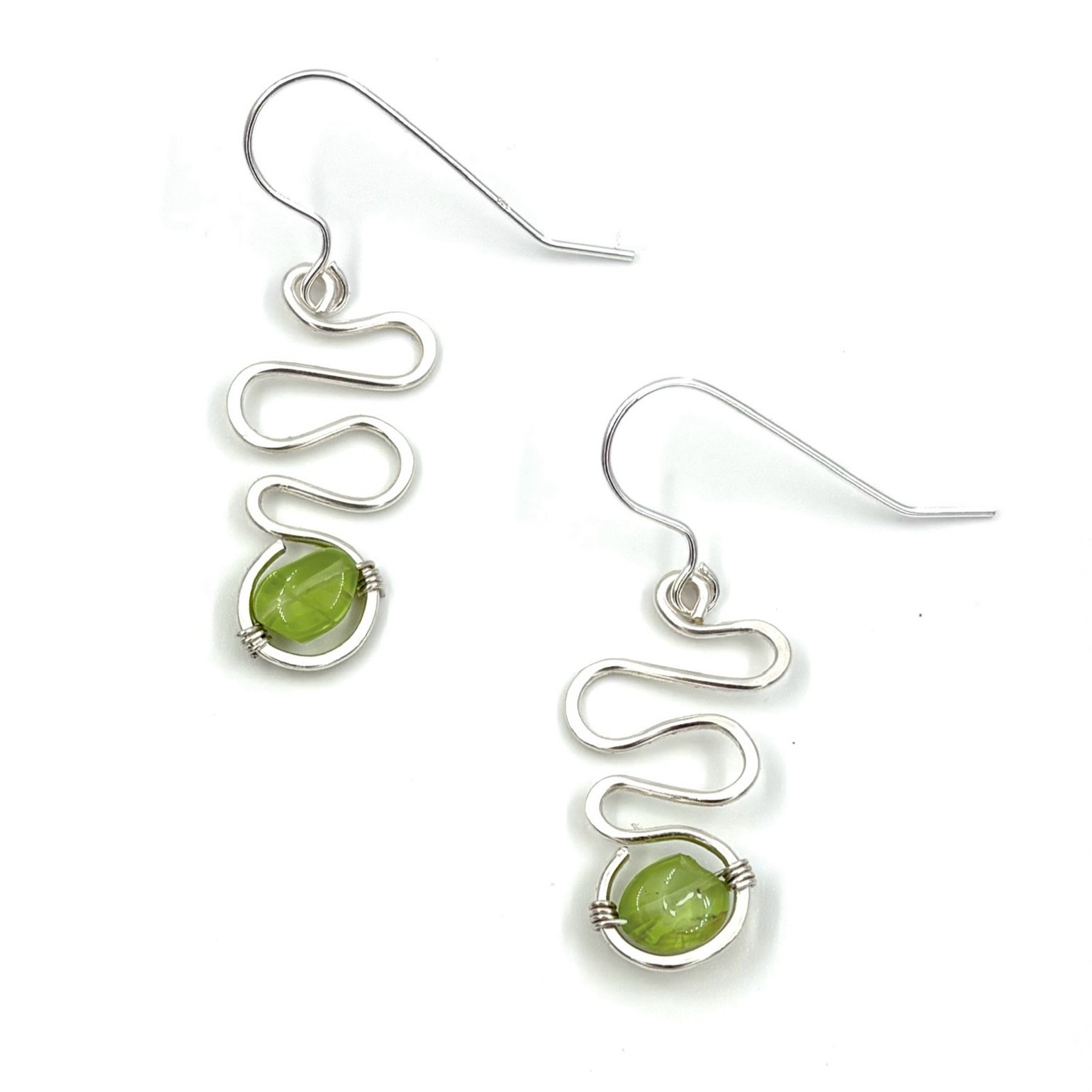 produktbild på silver-örhängen med peridot-sten